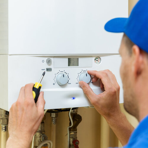 worker setting up a boiler for a heating system